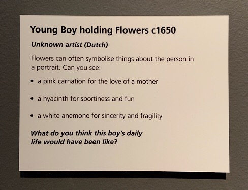 Young boy holding flowers information board