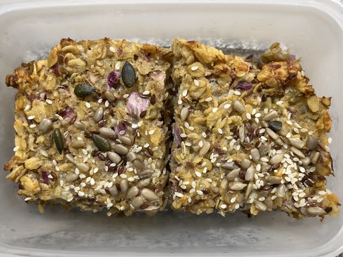 Savoury flapjacks with apple, cheese, and walnuts resting in a plastic box, ready to be eaten.