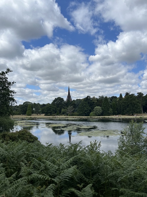 looking across the lake with the chapel spire standing above the trees in the skyline