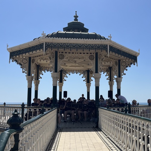 The Brighton Bandstand with the Østre Halsen Skolekorps performing inside, sea and blue sky behind