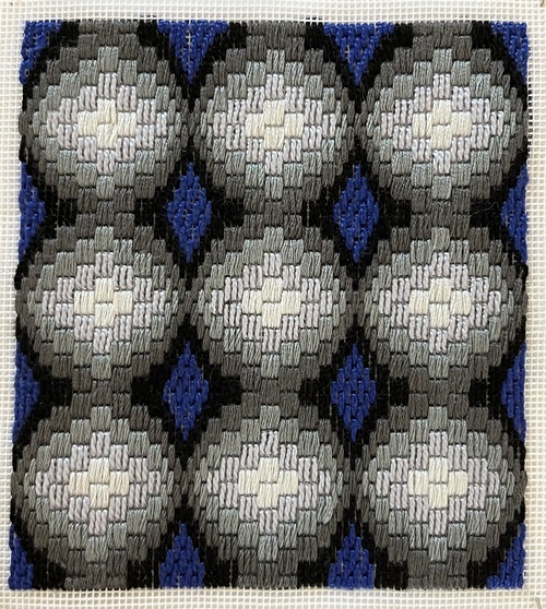 Unmounted Bargello needlework pinned out, grey and blue cross pattern on canvas