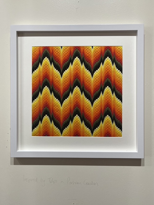 Framed Bargello needlework in orange, red and yellow flame stitch, inspired by tulips in Parham Garden