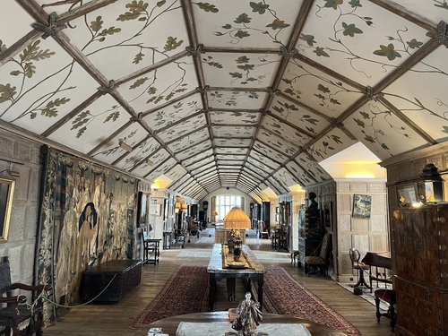 The Long Gallery at Parham House, with a painted foliage ceiling, tapestries and antique furniture