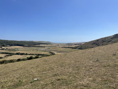 Looking down over the Cuckmere valley towards the sea, with cattle grazing in the fields below