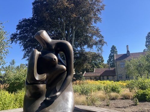 Henry Moore's Mother and Child: Block Seat sculpture in the foreground with Wakehurst's Elizabethan mansion behind