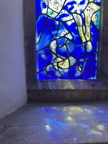 Deep blue stained glass panel with light reflecting on the sills