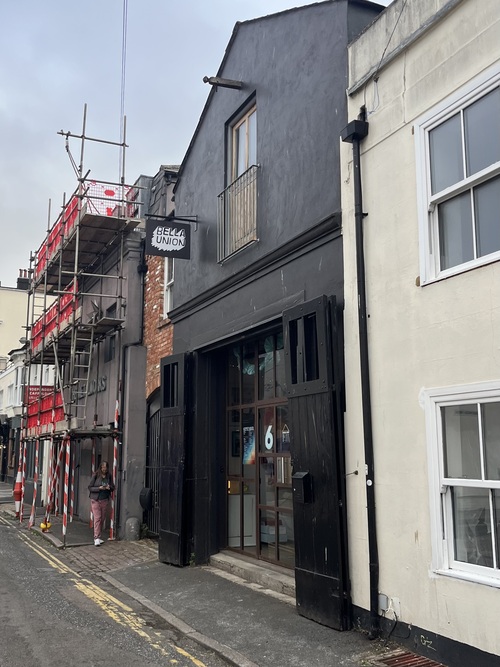 Exterior of Bella Union record shop and venue on a Brighton backstreet, black frontage with doors open