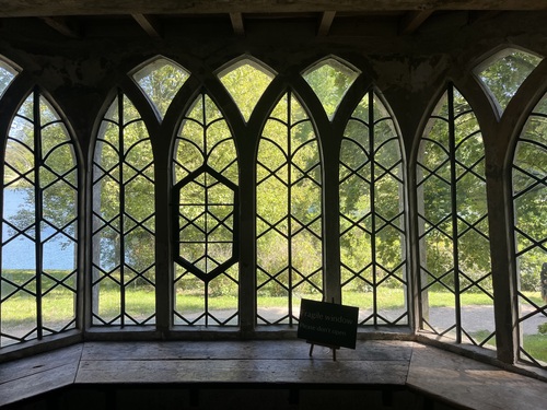 Looking out through the pointed Gothic arch windows of the Gothic Cottage towards the lake and trees