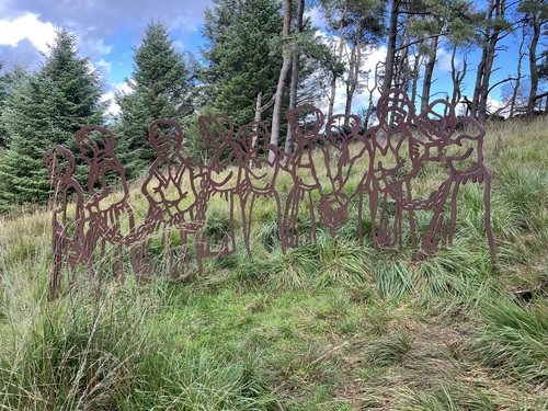 Metal sculpture of witches being led away