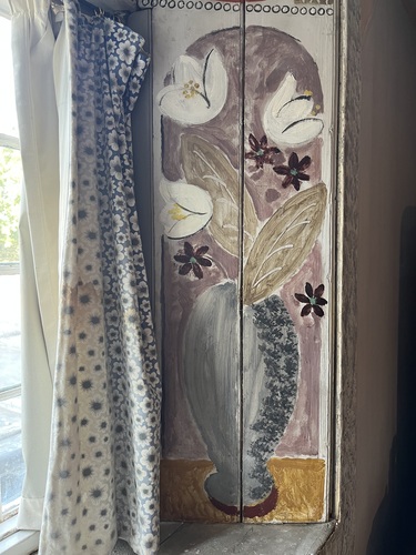 Painted decoration on a window shutter at Charleston, white flowers on a lilac ground