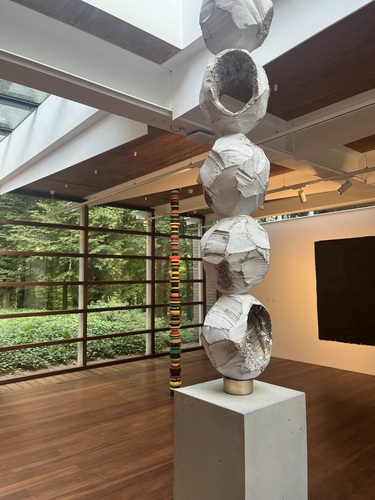 Two Eva Rothschild sculptures inside the Pigott Gallery, with the forest visible through the glass wall behind them