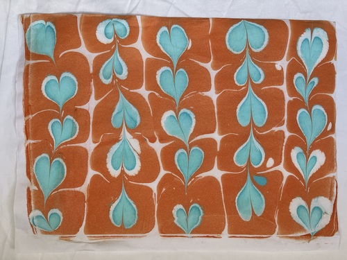 Attempt 1 of Ebru, worked into heart shapes using oranges, whites and turquoise acrylics
