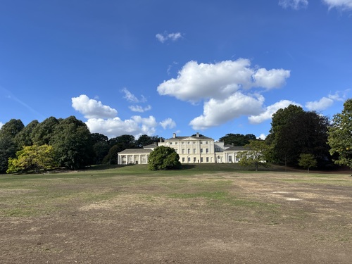 Kenwood House seen across the dry meadow below it