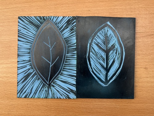 The two carved lino blocks side by side, the radiating leaf on the left and its inverse on the right